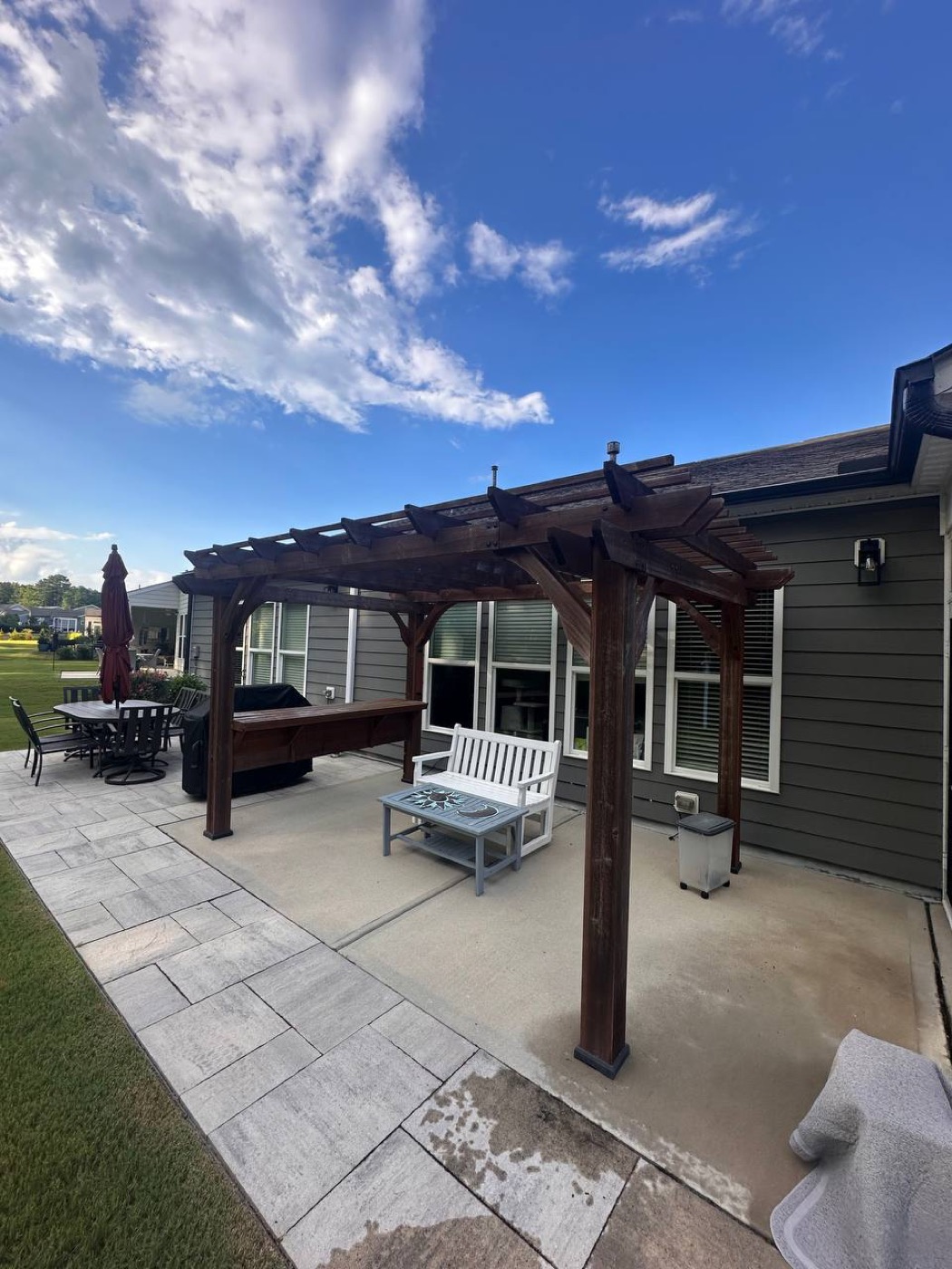 Stained cedar pergola over a stone patio