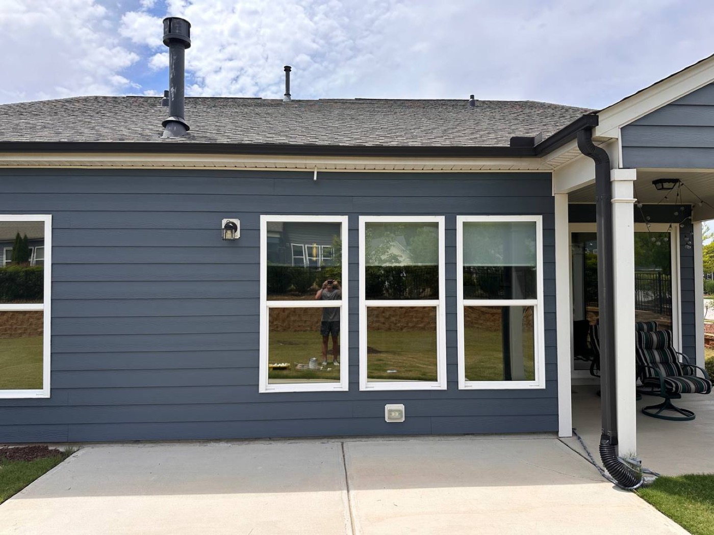 Repainted siding by a back patio after pressure washing